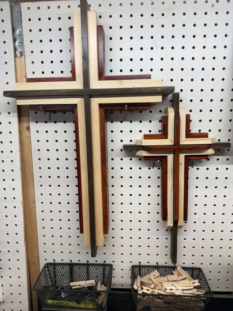 Two layered hardwood crosses in walnut, cedar and pine hanging in the workshop
